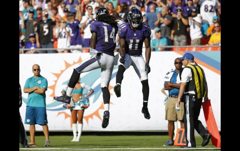 Los receptores Kamar Aiken y Marlon Brown celebran un touchdown. AFP / C. Trotman