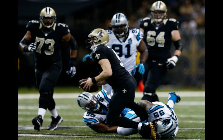 Drew Brees (9) de los Santos de Nueva Orleans es saqueado por los defensas de los Panteras de Carolina durante el partido. AFP / S. Gardner