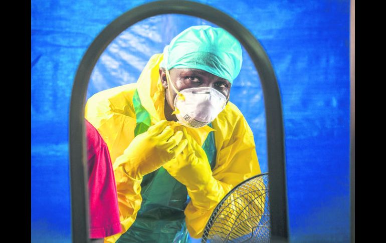 Sierra Leona. Un trabajador de salud se pone el equipo de protección antes de entrar en un centro de tratamiento en Freetown. AP /