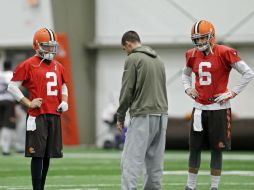 Johnny Manziel (2) y Brian Hoyer (6) escuchan al coordinador ofensivo durante una práctica. AP / M. Duncan