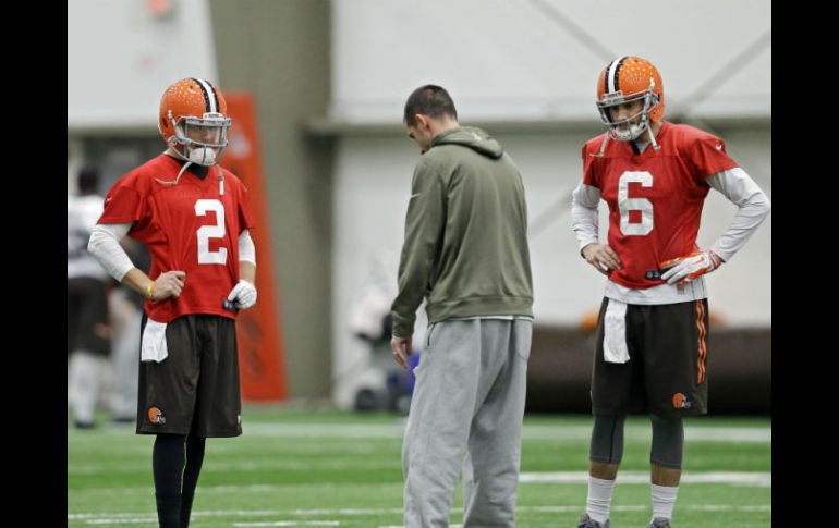 Johnny Manziel (2) y Brian Hoyer (6) escuchan al coordinador ofensivo durante una práctica. AP / M. Duncan