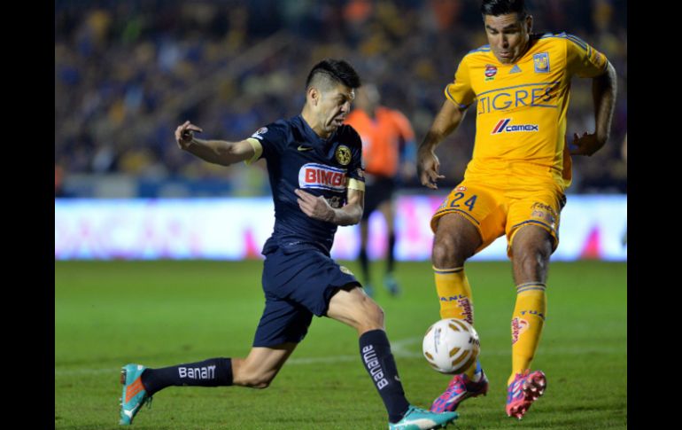 José Rivas (d) de Tigres, disputa el balón con O. Peralta del América durante el partido de ida de la final del Torneo Apertura 2014. EFE / M. Sierra