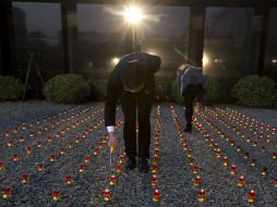 Trabajadores chinos encienden velas en una vigilia para el primer Día Conmemorativo Nacional de las Víctimas de la Masacre en 1937. AP / N. Guan