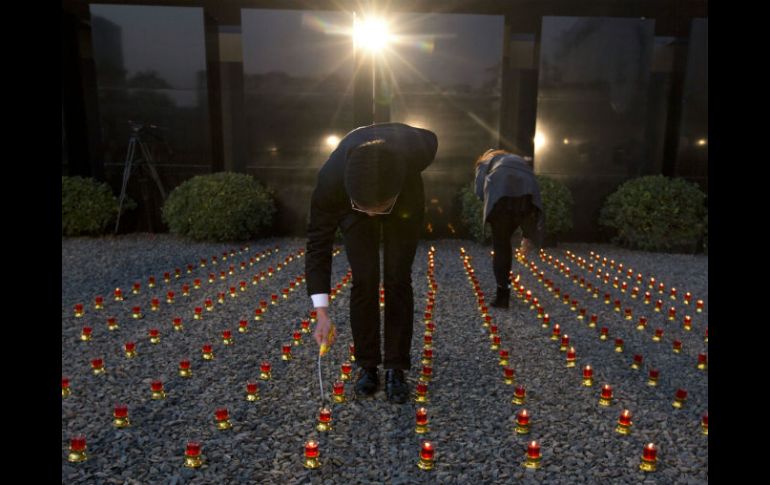 Trabajadores chinos encienden velas en una vigilia para el primer Día Conmemorativo Nacional de las Víctimas de la Masacre en 1937. AP / N. Guan