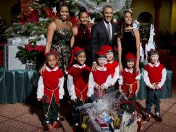 La familia Obama se tomó la foto del recuerdo con seis pequeños vestidos de duendes. AP / M. Balce