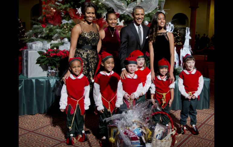 La familia Obama se tomó la foto del recuerdo con seis pequeños vestidos de duendes. AP / M. Balce