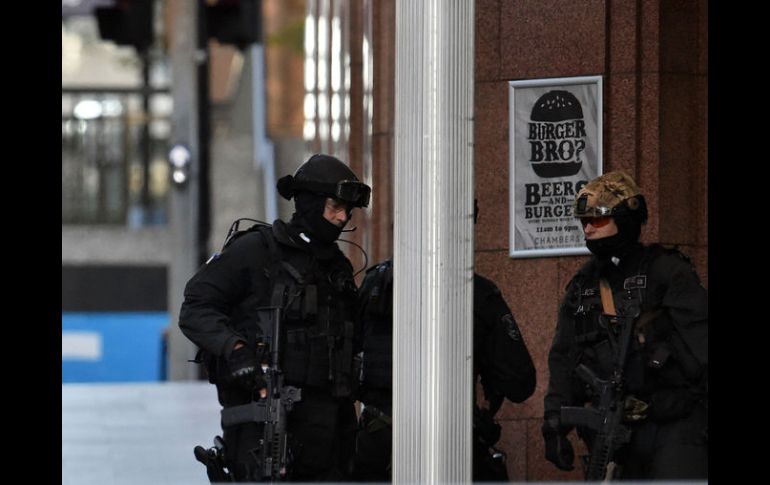 Policías armados vigilan a las afueras de la cafetería donde permanecen los rehenes. AFP /