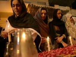 Mujeres pakistanís encienden velas en memoria de las víctimas de este día. AFP /