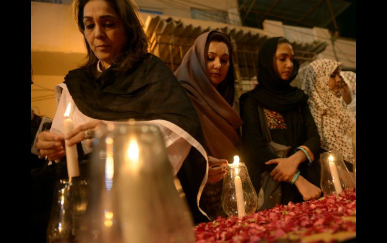 Mujeres pakistanís encienden velas en memoria de las víctimas de este día. AFP /