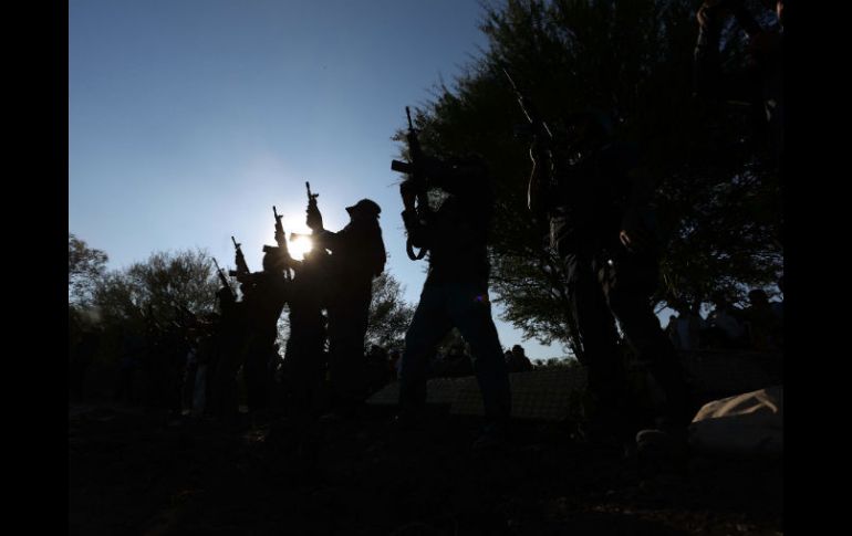 Elementos de la Fuerza Rural accionan sus armas en honor a Manuel Mora, el hijo de Hipólito que fue asesinado en el tiroteo del martes. AFP / STR