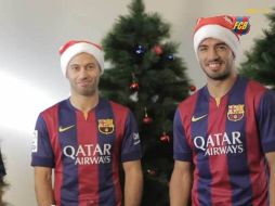 Javier Mascherano y Luis Suárez lucen un colorido gorro navideño para el mensaje. ESPECIAL /