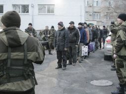 Prisioneros ucranianos esperan en fila para ser transportados al lugar del intercambio con los rebeldes pro rusos. EFE / A. Ermochenko