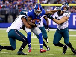 Odell Beckham Jr. (13) de los Gigantes corre con el balón mientras Connor Barwin (98) de las Águilas intenta tacklearlo. AFP / A. Bello