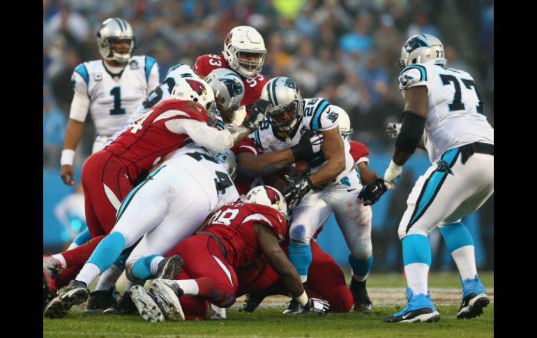 Jonathan Stewart (28), de los Panteras de Carolina, pelea el balón contra los Cardenales de Arizona. AFP / S. Lecka