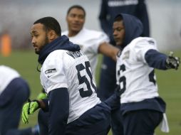 El apoyador de los Halcones Marinos, K.J. Wright (50), realiza estiramientos junto a su equipo durante la práctica previa al partido. AP / T. S. Warren