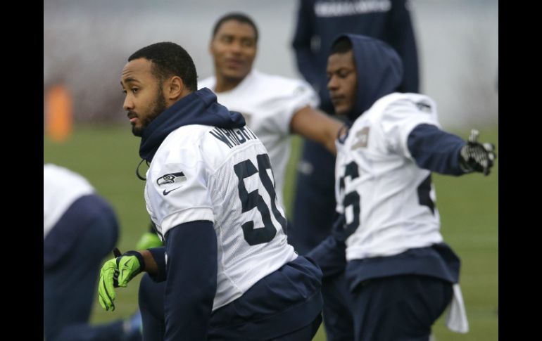 El apoyador de los Halcones Marinos, K.J. Wright (50), realiza estiramientos junto a su equipo durante la práctica previa al partido. AP / T. S. Warren