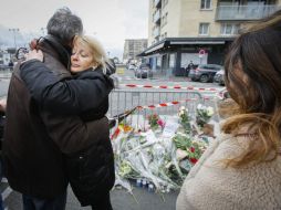 Personas arriban al supermercado judío para ofrecer flores y oraciones por las víctimas mortales del atentado terrorista. EFE / O. Hoslet