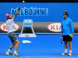 Rafael Nadal, entrena en la Rod Laver Arena, cancha central de Melbourne Park, ante la mirada de su entrenador, el tío Toni. AP / B. Armangue