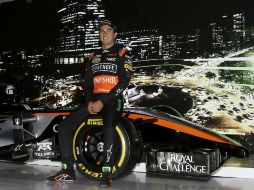 Sergio Pérez posa con el rediseñado auto de Force India, presentado ayer en la Ciudad de México. EFE / A. Cruz