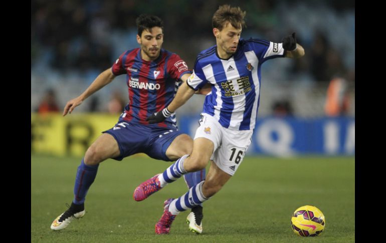 El centrocampista de la Real Sociedad, Sergio Canales (d) disputa el balón con el defensa del Eibar, Eneko Bóveda (i). EFE / J. Herrero