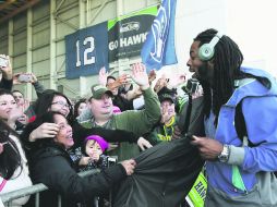 Apoyo. El cornerback de los Halcones Marinos de Seattle, Richard Sherman atiende a decenas de aficionados antes de partir a Arizona. AP /