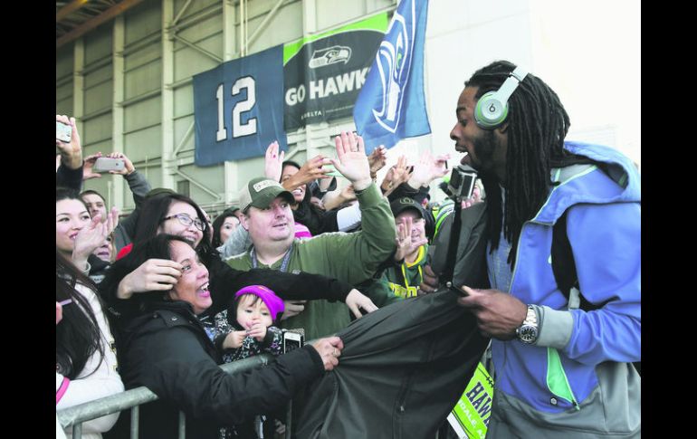 Apoyo. El cornerback de los Halcones Marinos de Seattle, Richard Sherman atiende a decenas de aficionados antes de partir a Arizona. AP /