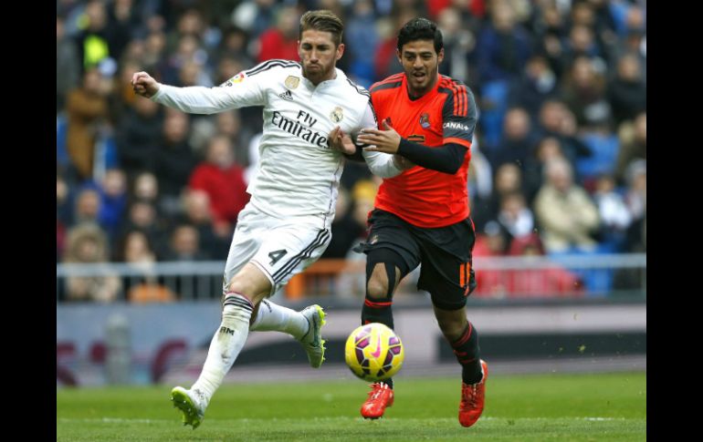 El defensa del Real Madrid Sergio Ramos (i) disputa un balón con el delantero mexicano de la Real Sociedad Carlos Vela (d). EFE / J. Hidalgo