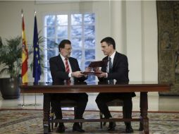 El presidente del gobierno Mariano Rajoy (I) y el líder del opositor Partido Socialista Pedro Sánchez (D) firman el acuerdo. EFE / F. Alvarado