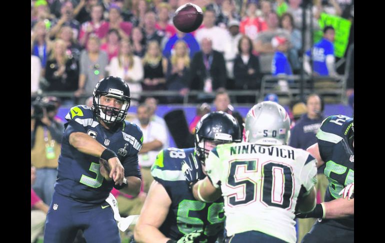 Russell Wilson (izquierda), quarterback de los Halcones Marinos de Seattle, lanza el pase que provocó la intercepción. AFP / R. Carb