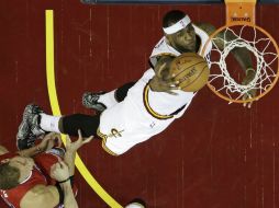 LeBron James clava el balón superando la marca de Blake Griffin. AP / T. Dejak