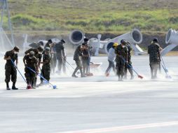 Cerca de 100 soldados participaron en las operaciones de limpieza barriendo la pista del aeropuerto. AFP / J. Ordonez