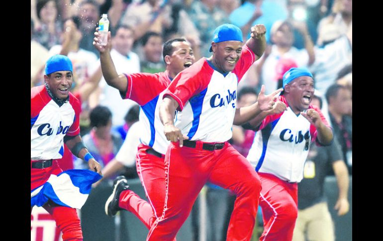 Frederich Cepeda al frente de algunos miembros del equipo cubano de beisbol, festeja el campeonato. AFP / P. Richards