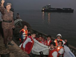 Rescatistas de Bangladesh cargan el cuerpo de una de las víctimas del ferry. AP / A. Ahad