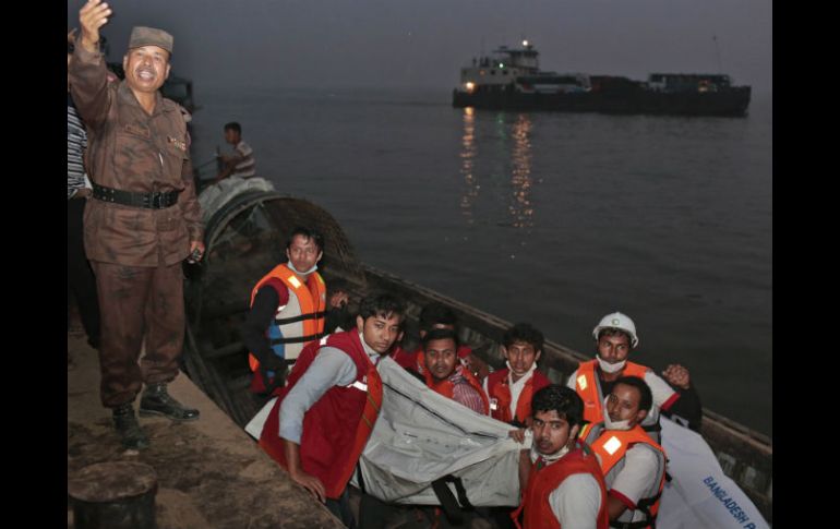 Rescatistas de Bangladesh cargan el cuerpo de una de las víctimas del ferry. AP / A. Ahad