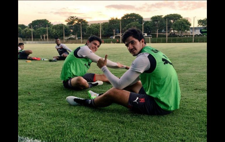 Ponchito González y Carlos Treviño (14) durante la práctica que realizaró Atlas en el centro deportivo Toca da Raposa II, del Cruzeiro. TWITTER / @atlasfc