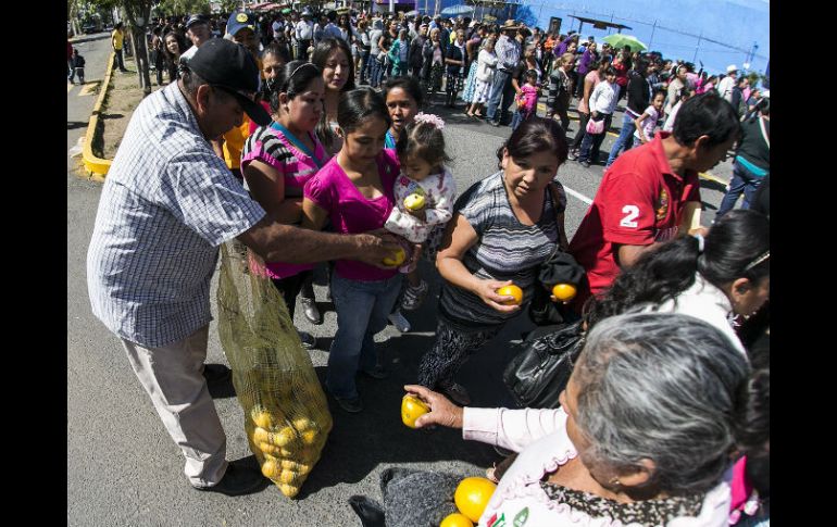 A su arribo al Auditorio Benito Juárez, a los asistentes les regalaron naranjas. EL INFORMADOR / A. Hernández