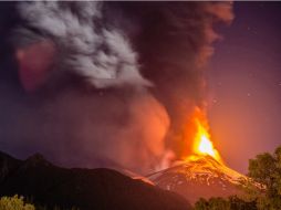 El material que expidió violentamente el Villarrica alcanzó los tres kilómetros de altura e iluminó la zona. AFP / F. Negroni