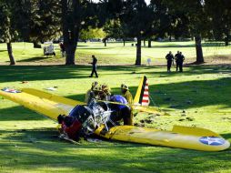 Oficiales revisan el estado de la nave  Ryan Aeronautical modelo ST3KR tras el aterrizaje del actor en un campo de golf en Penmar. AP / D. Dovarganes