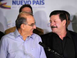 Humberto de la Calle (izq.), jefe negociador del gobierno colombiano, sonríe al  mayor general Javier Flórez de las FARC. AFP / Y. Lage