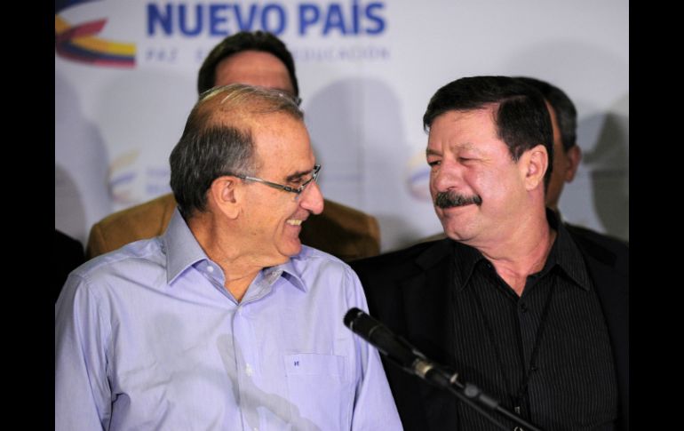 Humberto de la Calle (izq.), jefe negociador del gobierno colombiano, sonríe al  mayor general Javier Flórez de las FARC. AFP / Y. Lage