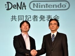 Satoru Iwata (d) dijo que ambas compañías lanzarán un juego este año para smartphones. AFP / Y. Tsuno