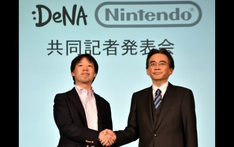 Satoru Iwata (d) dijo que ambas compañías lanzarán un juego este año para smartphones. AFP / Y. Tsuno