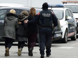 Un policía acompaña a familiares de una de las víctimas que viajaban en el avión Airbus 320. AFP / L. Gene