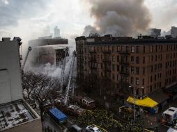 Los bomberos seguían rociando agua sobre los edificios horas después de la explosión. AFP / A. Burton