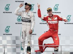 Desatado. El piloto alemán Sebastian Vettel (Ferrari) celebra con paso de baile en el podio de Malasia frente a Lewis Hamilton. EFE /