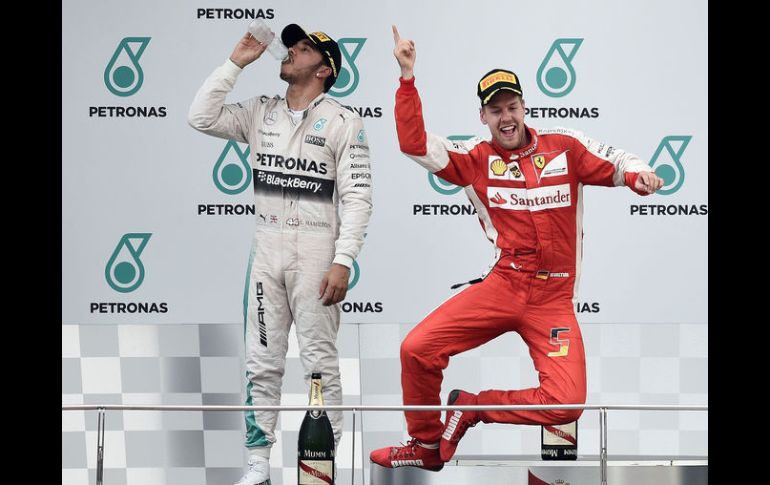 Desatado. El piloto alemán Sebastian Vettel (Ferrari) celebra con paso de baile en el podio de Malasia frente a Lewis Hamilton. EFE /