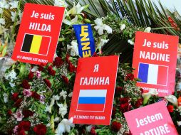 Un flujo pequeño y constante de visitantes caminó frente a flores dejadas en honor de las víctimas y banderas de sus nacionalidades. AP / H. Dridi