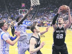 Orlando. Tiago Splitter (número 22) de los Spurs, se prepra para realizar un tiro al aro durante el partido de ayer frente al Magic. AP / J. Raoux