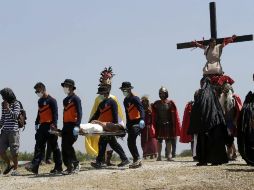 Un penitente es trasladado en camilla tras haber sido crucificado con clavos durante la representación. EFE / R. B. Tongo