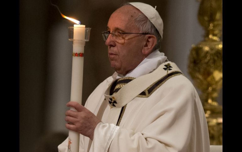 Con una estaca, calentada por el fuego, Francisco marca un gran cirio pascual con una cruz y los símbolos de las letras Alfa y Omega. AP / A. Medichini